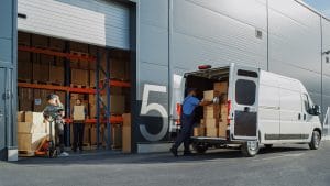 Outside of Logistics Retailer Warehouse With Manager Using Tablet Computer Diverse Workers Loading Delivery