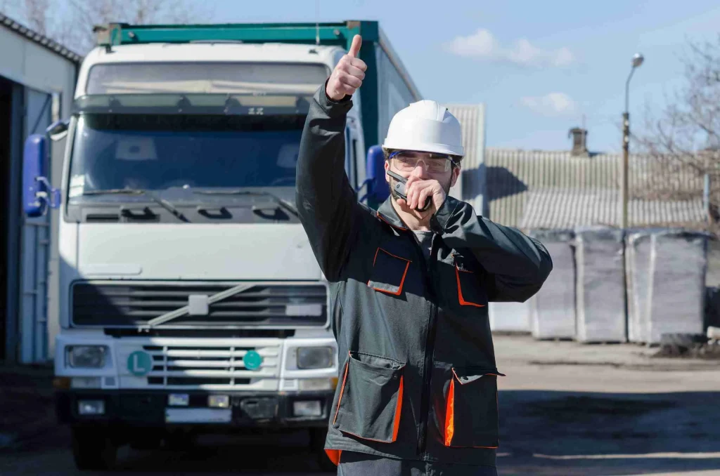 Worker overlooking work site directing a truck